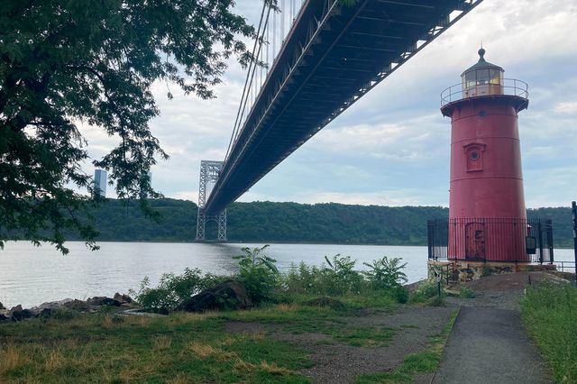 a red lighthouse underneath the G.W. Bridge